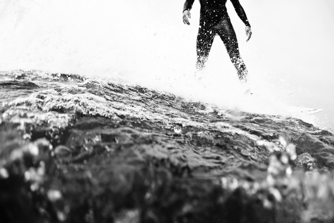 Black and white photo of a surfer riding a wave